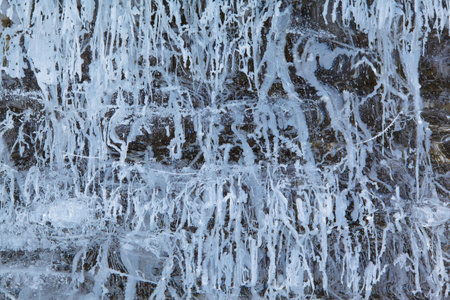 Texture of winter ice on a stone cliff. Blue natural ice background.の写真素材