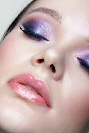 Portrait of young female face with eyes closed. Woman with lilac beauty eyes makeup. Girl with perfect skin and purple smoky eyes eye shadows.の写真素材