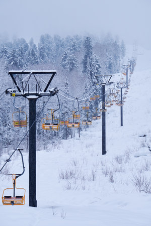 Teletsky Altai winter mountain ski resort near Iogach. Elevator on mount and forest background under snowfall.の写真素材