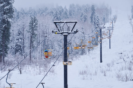 Teletsky Altai winter mountain ski resort near Iogach. Elevator on mount and forest background under snowfall.の写真素材