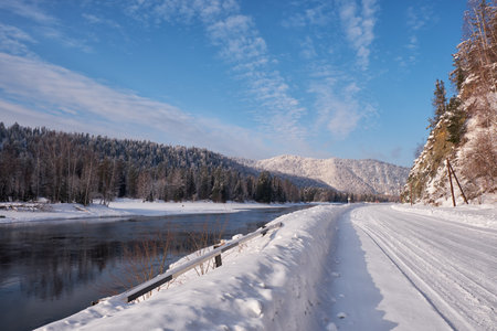 Altai winter road and river Biya in winter season. Banks of river are covered by ice and snow. Altai, Siberia, Russiaの写真素材