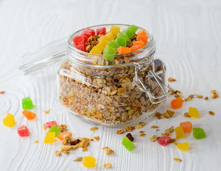Muesli with dried fruit and candied fruit on a white wood background, selective focus.の写真素材