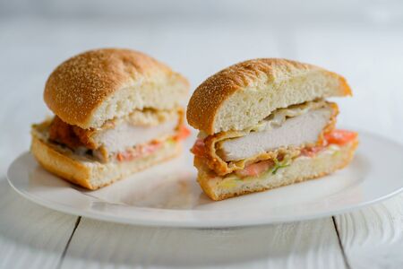 Fresh tasty chicken burger sectional view on wooden tableの写真素材