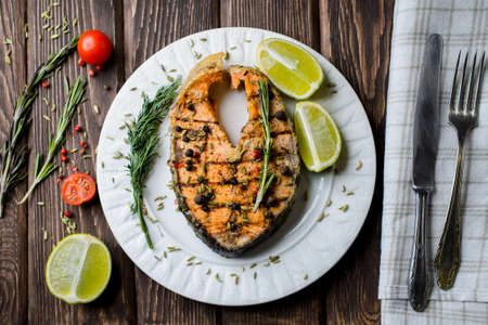Grilled salmon on white plate on wooden backgroundの写真素材