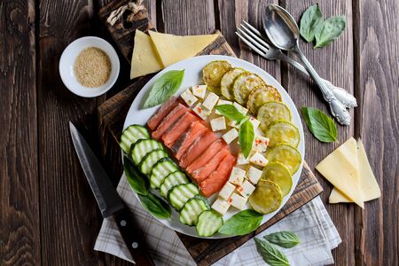 Plate with the fried vegetable marrows salmon salad on rustic table, cuttingの写真素材