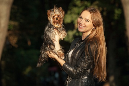 girl with long hair holding a dogの写真素材