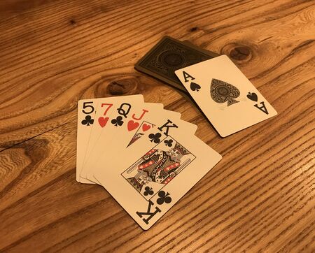 Old playing cards on wooden table. Poker