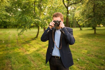 Young photographer with camera in his handsの写真素材