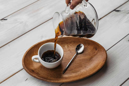 Americano coffee brewing in a teapot a cup. Coffee in cup on wooden.の写真素材
