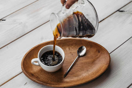 V60 funnel coffee, freshly brewed coffee. Coffee V60 with cup on wooden table.の写真素材