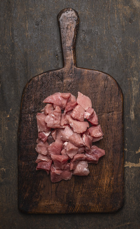 raw stew on the old board on a dark textured background, top viewの写真素材