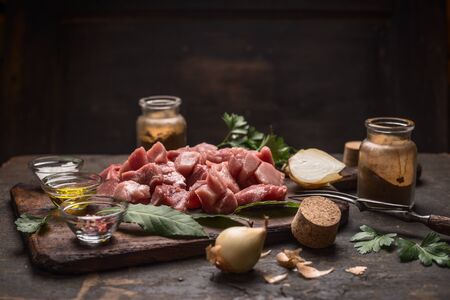 ingredients for goulash or stew raw meat herbs spices on old cutting board on rustic wooden backgroundの写真素材