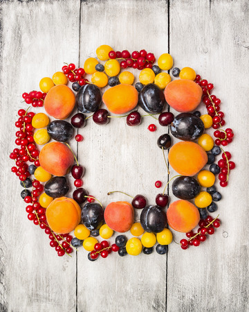fresh red currants, plums, blackberries,cherry, blueberries, apricots  on a white background , top view, frameの写真素材