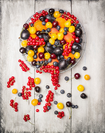 fresh red currants, plums, blackberries,cherry, blueberries, apricots in a basket on a white background , top viewの写真素材