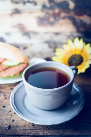 breakfast with a cup of tea on a rustic wooden background, place for textの写真素材