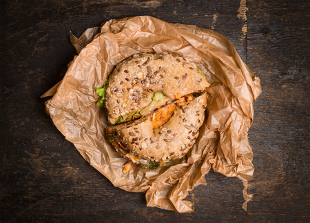 Sandwich on a Bagel on crumpled wrapping paper on rustic wooden background,top viewの写真素材