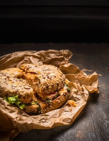 Hearty Breakfast Sandwich on a Bagel with chiken and salad leaves and Cheese on rustic wooden background, close upの写真素材