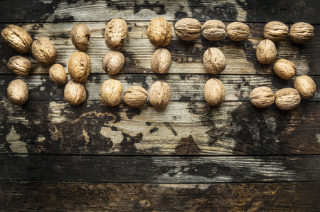 walnuts, laid out in the word "nuts" on wooden rustic background, top viewの写真素材
