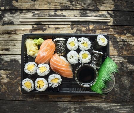 Sushi menu set  in black transport box on dark wooden background, top viewの写真素材