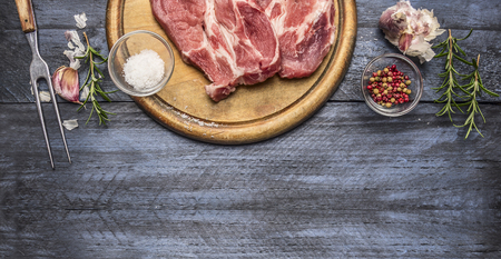 ingredients and seasonings for the roast pork on a board with a fork, on a wooden background, Borderの写真素材