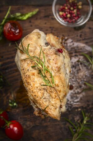 Roast chicken breast with Rosemary and vegetables on dark wooden background, top view, close upの写真素材