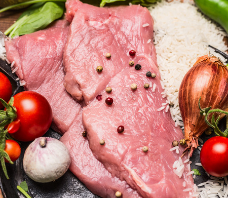 raw steak turkey tomatoes garlic onion rice in a frying pan top view close upの写真素材
