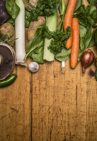 Fresh autumn vegetables and mushrooms on brown rustic cutting board top viewの写真素材