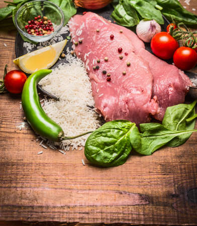 fresh raw steak of turkey with vegetables with rice and vegetables and spices on wooden rustic background close upの写真素材