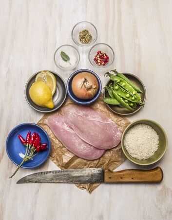 raw turkey on paper with knife lemon meat onion peas salt pepper on wooden rustic background top viewの写真素材