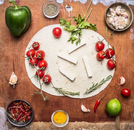 ingredients for burritos, vegetables, lime, spices and herbs on wooden rustic background top viewの写真素材