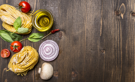 Ingredients for cooking vegetarian pasta on wooden rustic background top view close up border, with text areaの写真素材