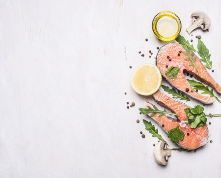 Concept preparation raw salmon steak with herbs, parsley, olive oil and salt on vintage cutting board on a wooden rustic background top view close up border, place for textの写真素材