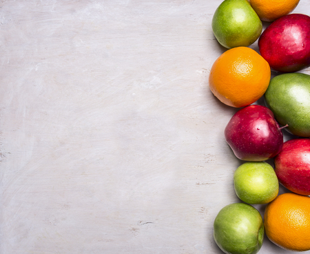 concept of healthy food, vitamins, various fruits, various apples, mangoes, oranges border ,with text area on wooden rustic background top view close upの写真素材