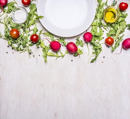 different ingredients for salad, radish, cherry tomatoes and seasonings, the plates are laid out around border ,place for text top viewの写真素材