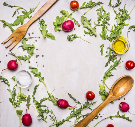 Healthy foods, cooking and vegetarian concept salad with cherry tomatoes, radishes, spices and wooden spoon and for place for text, frameの写真素材