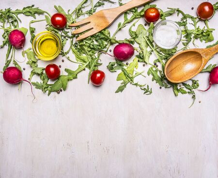 Healthy foods, cooking and vegetarian concept salad with cherry tomatoes, radishes, spices and wooden spoon and fork border ,place for textの写真素材