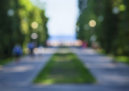 blurred landscape stone road through the park to the beach, trees, people, silhouettes, background, bokehの写真素材