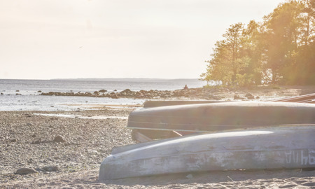 blurred retro landscape, sea shore with overturned boats on the beach in sunny summer dayの写真素材