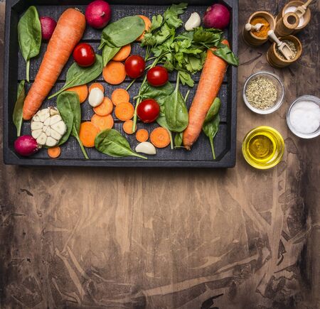 concept cooking vegetarian meals, a variety of vegetables, herbs and spices, laid beside pepper, oil and salt, place for textの写真素材