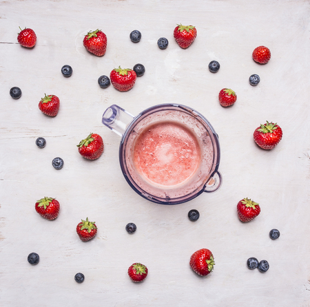 fresh ingredients for smoothies   and electric blender on white wooden background, top view . Superfoods and health or detox diet food conceptの写真素材