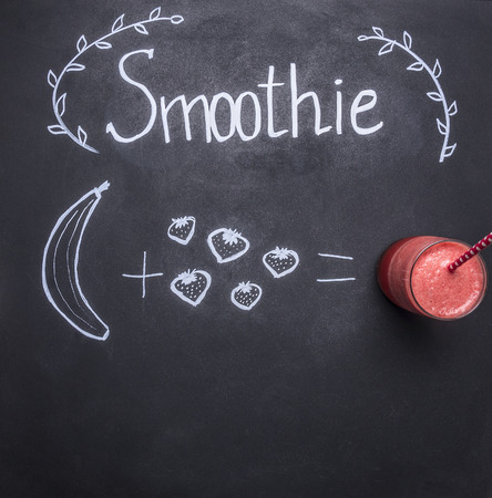concept cooking smoothies from fruit and vegetables, on the chalkboard, drawn banana and strawberries top viewの写真素材
