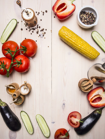 vegetarian concept tomatoes, whole pepper, red bell pepper, corn, cucumbers and seasonings on wooden rustic background top view close upの写真素材