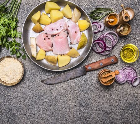 raw turkey breast with potato, pear, red onion and herbs, with a variety of condiments, vintage knife for meat, on a granite rustic background, top view, space for textの写真素材