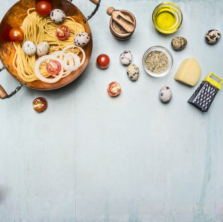 concept cooking homemade vegetarian pasta with cherry tomatoes, parmesan cheese, quail eggs and seasonings, pasta in a copper bowl with the other ingredients, Border, place for textの写真素材
