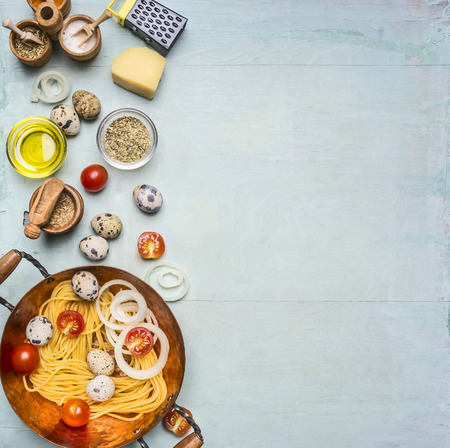 concept cooking homemade vegetarian pasta with cherry tomatoes, parmesan cheese, quail eggs and seasonings, pasta in a copper bowl with the other ingredients, Border, place for textの写真素材