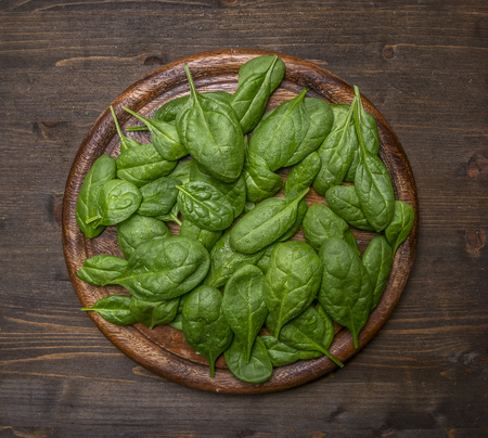 Healthy foods, cooking and vegetarian concept fresh spinach leaves on cutting boardの写真素材