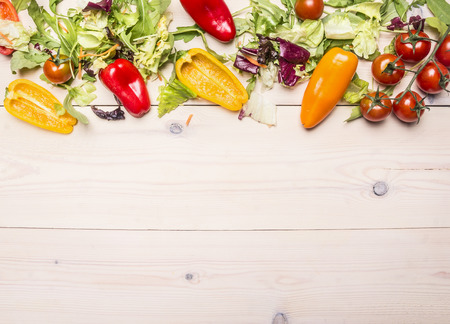Superfoods and healthy lifestyle or detox diet food concept various vegetables and herbs on a white wooden table, cherry tomatoes, bell peppers, arugula, space for text, Borderの写真素材