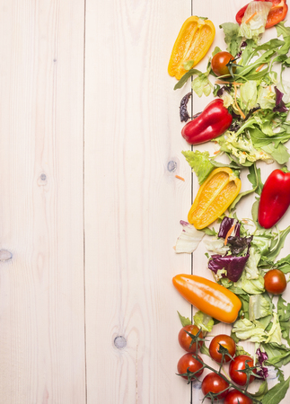Superfoods and healthy lifestyle or detox diet food concept various vegetables and herbs on a white wooden table, cherry tomatoes, bell peppers, arugula, space for text, Borderの写真素材