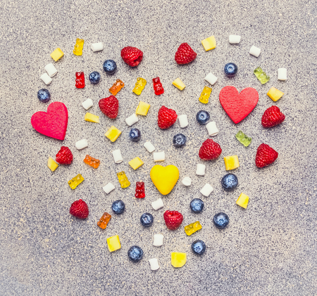various berries, marmalade and marshmallow, lined with a heart on a granite background, valentines day, top viewの写真素材