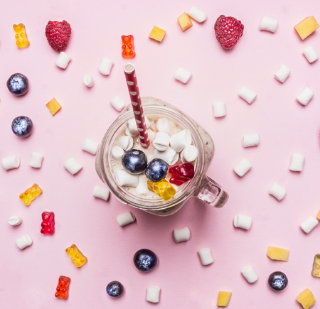 healthy food, milk shake with berries, marshmallows and jelly on a pink background, a number of ingredients laid out, top viewの写真素材